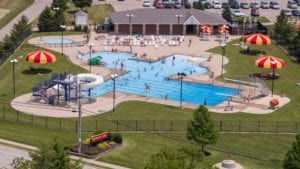 Overhead view of New Bremen pool with lots of patrons and poolhouse in background